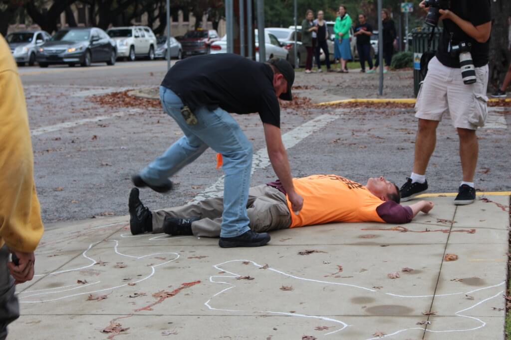 A gun-rights advocate sprays ketchup on a supposed victim of Saturday's mock mass shooting in Austin. (Anna Casey)