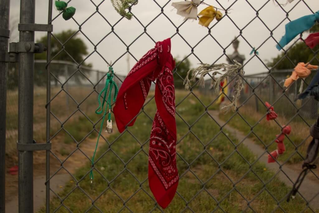 Scarves decorate the fence surrounding the mass grave in Shannon County, now Oglala Lakota County, where victims of the Wounded Knee Massacre are buried. (Courtney Columbus/News21)